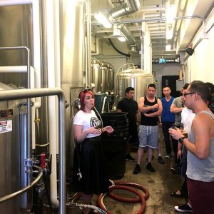 Learning about the craft beer brewing process, behind the scenes at a craft beer tour in Kelowna.